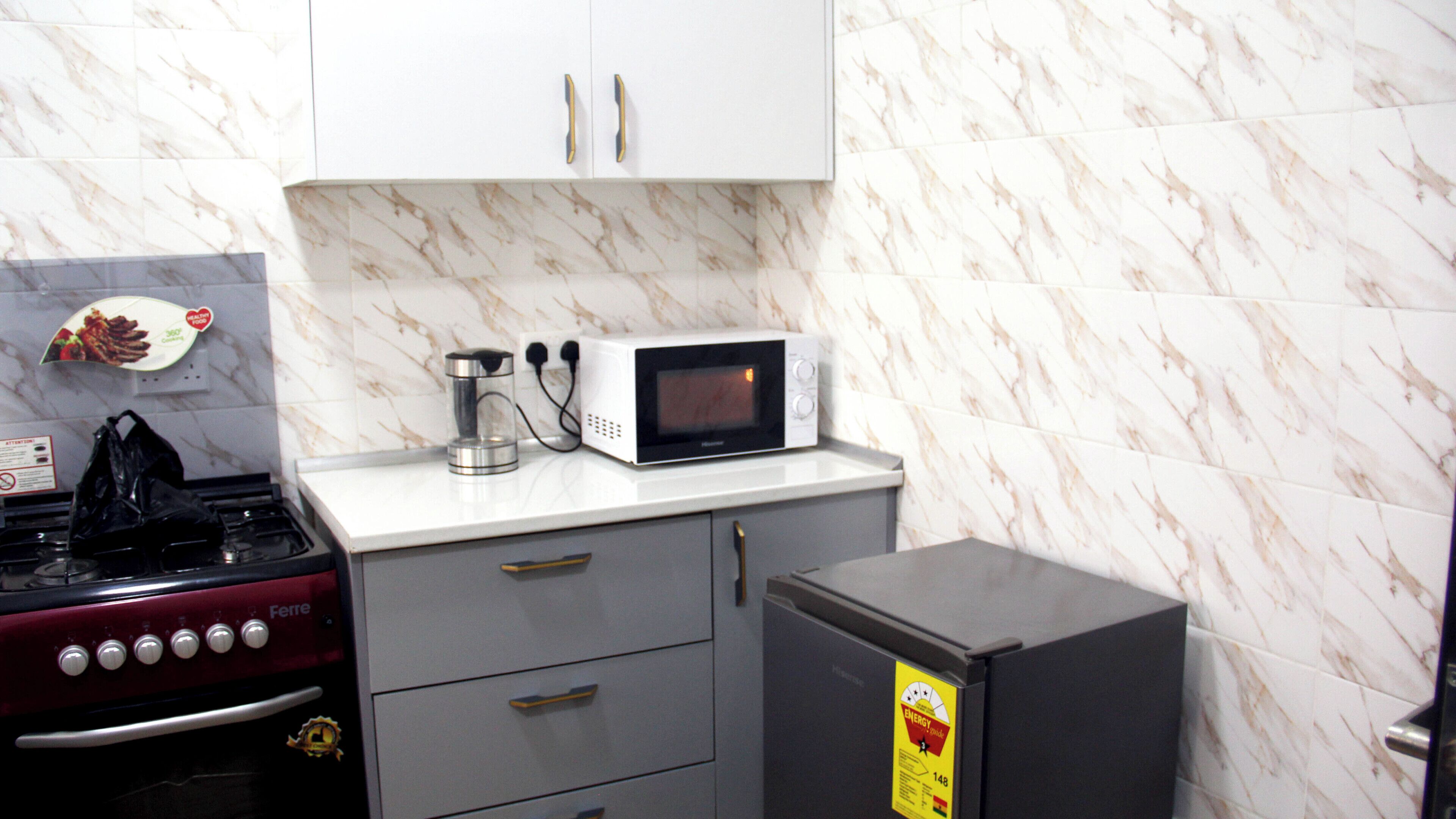 A kitchen with a stove, microwave, and refrigerator.