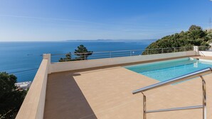 Una piscina en la azotea con vistas despejadas al mar y a la costa lejana.