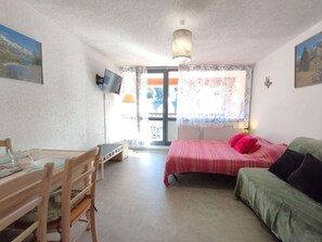 Cozy retreat with a comfortable bed, sofa, and desk, offering a functional space to unwind.