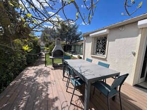 A patio with a table and chairs, a stone oven, and a garden path. - Quiet villa in Balaruc with aircon and parking (Balaruc-les-Bains)