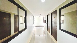 Un long couloir étroit, avec des portes des deux côtés, menant à des pièces individuelles.