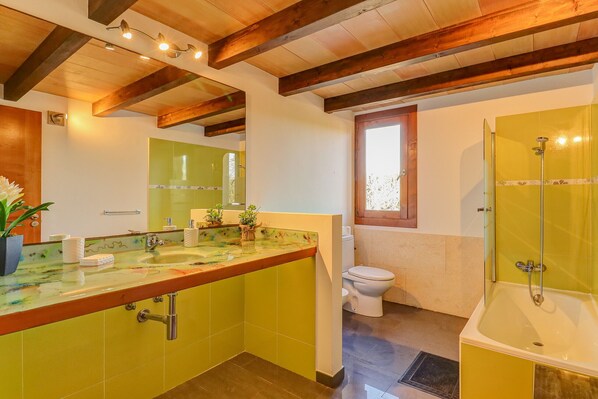 A bathroom with a large sink, toilet, and bathtub, all in a bright yellow color scheme. - Son Mieres by Rentallorca (Petra)
