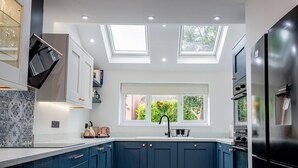 A modern kitchen with skylights, a built-in oven, and a water dispenser. - Exquisite renovation in central location (Hereford)
