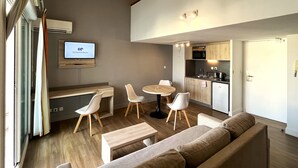 A modern apartment with a living room, dining area, and kitchen.