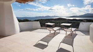 A balcony with two tables and a view of the sea and mountains. - MANOR HOUSE (ARZACHENA LOC. CAPRICCIOLI)