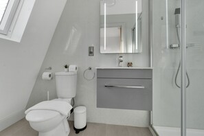 A modern bathroom with a toilet, sink, and shower.
