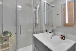 Apartamento elite | Banheiro | Chuveiro, produtos de toalete grátis, secador de cabelo