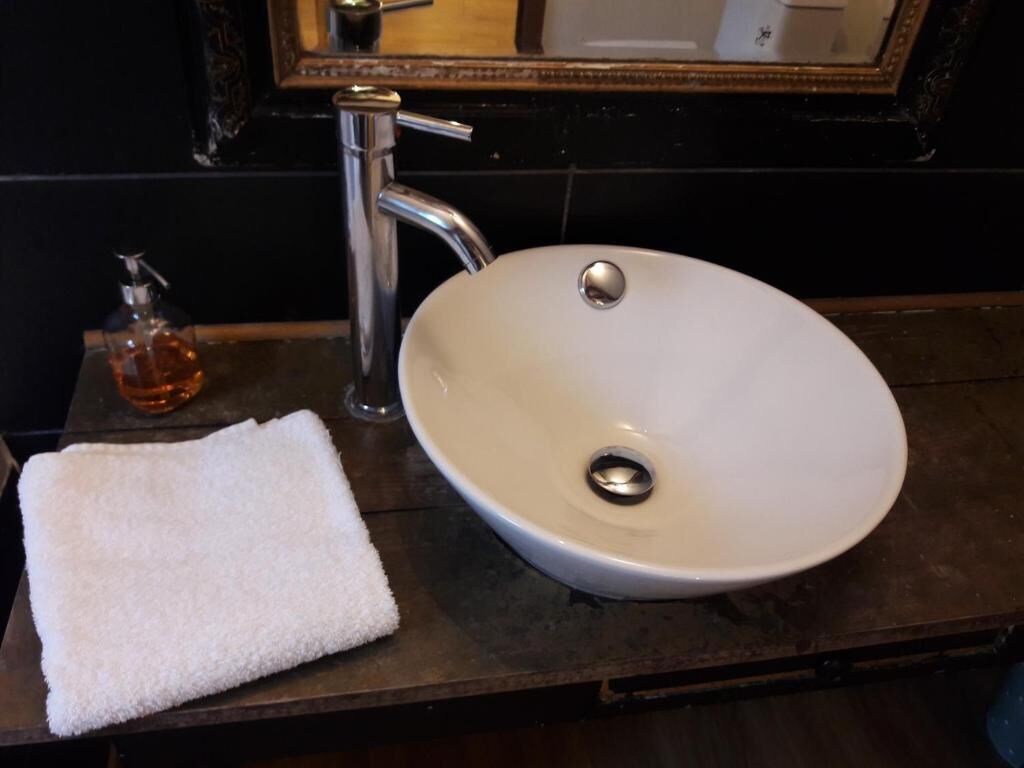 Une salle de bain avec un lavabo blanc, un miroir et une serviette posée sur le comptoir.
