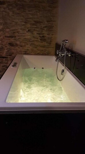 A bathtub with running water, a shower head, and a faucet. - Manoir de Barbotin (Ploërmel)