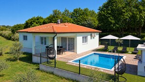 A two-story house with a swimming pool, outdoor seating, and a fenced patio area. - Villa Petar by Villas Guide (Buroli)