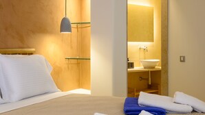 Une chambre d’hôtel avec un lit, une salle de bain avec un lavabo et un miroir.