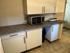 Kitchen area with microwave oven, sink, and cabinet.
