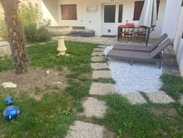 Enjoy a serene outdoor space with a garden, seating area, and covered patio.