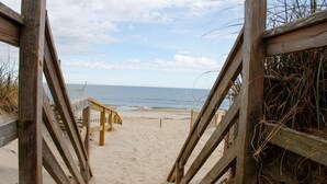 Une promenade en bois longeant la plage et menant au rivage.