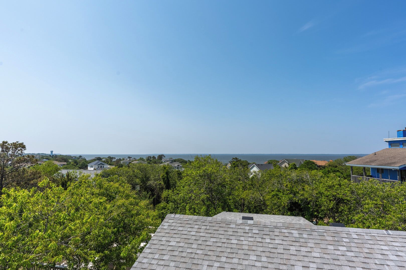 A residential area with houses and a clear view of the ocean.