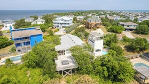 Un quartier résidentiel situé sur la côte, avec des maisons, une piscine et une vue sur la mer.