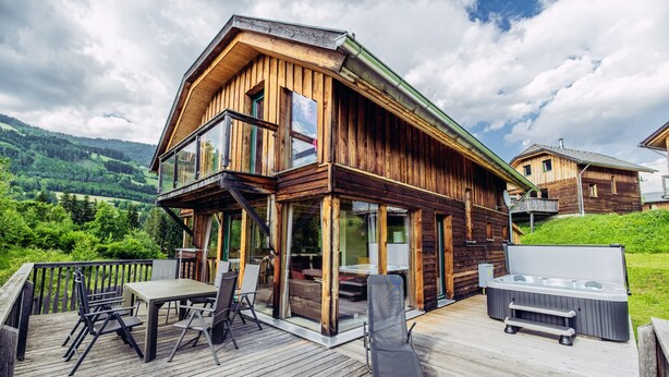 A wooden cabin with a deck, outdoor seating, and a hot tub. - Woody 1 - near ski resort at unique location (St. Georgen am Kreischberg)