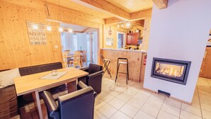 A cozy wooden interior with a dining area, kitchen, and fireplace. - Woody 12 - with sauna & 2 cozy terraces (St. Georgen am Kreischberg)