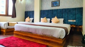 A hotel room with two beds, a red rug, a grey textured wall, and a framed picture. - Aurora Gangtok (Gangtok)