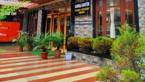 A hotel named "Aurora Gangtok" with a stone facade, a red awning, and a signboard indicating rooms, restaurant, and banquet services. - Aurora Gangtok (Gangtok)