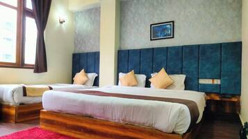 A hotel room with two beds, a red rug, a grey textured wall, and a framed picture.