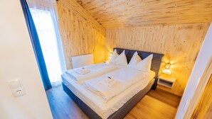 A wooden-paneled bedroom with a double bed, bedside lamps, and a window with curtains. - Woody 17 - Hillside Chalet Kreischberg (St. Georgen am Kreischberg)