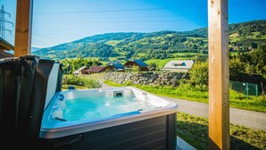 Een hottub met uitzicht op een landelijk landschap, met huizen en heuvels.