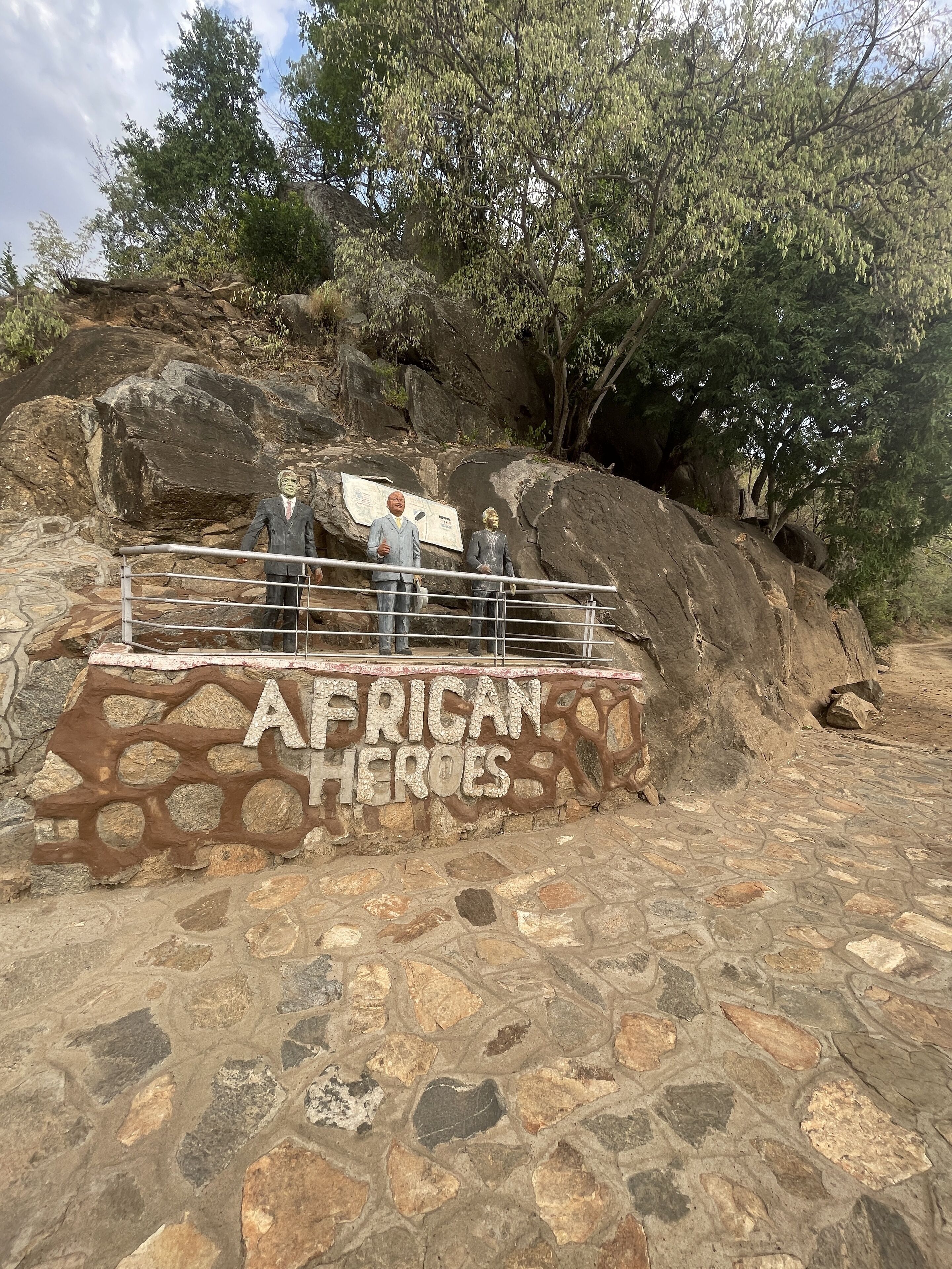 A stone pathway leading to a viewing platform with a sign reading "African Heroes."