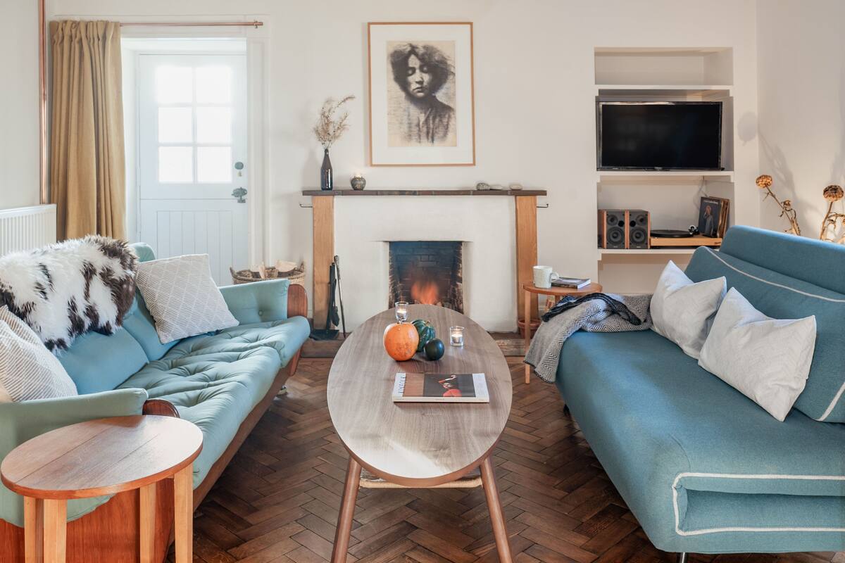 A living room with a fireplace, a sofa, a coffee table, and a television.