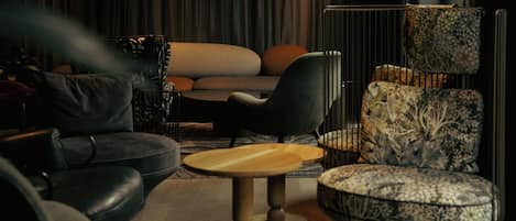 A modern living room with a sofa, chairs, a coffee table, and a patterned armchair.