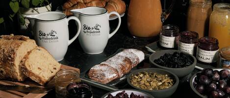A breakfast table with bread, pastries, and various spreads.