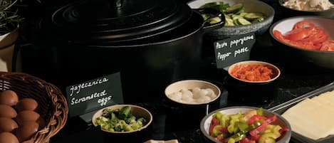 Una encimera de cocina con diversos alimentos e ingredientes, incluyendo una cesta de huevos, cuencos con verduras y un bloque de tofu.