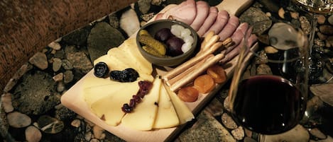 Una tabla de quesos con diferentes tipos de queso, frutas y frutos secos sobre una mesa de mármol.