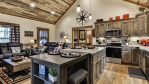 A spacious kitchen with a large island, wooden cabinets, and modern appliances.