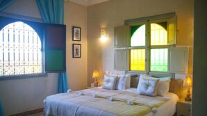 A neatly made bed with white linens and pillows, a bedside lamp, and a window with curtains. - Villa Atika Maison d'hôtes & SPA (Marrakech)