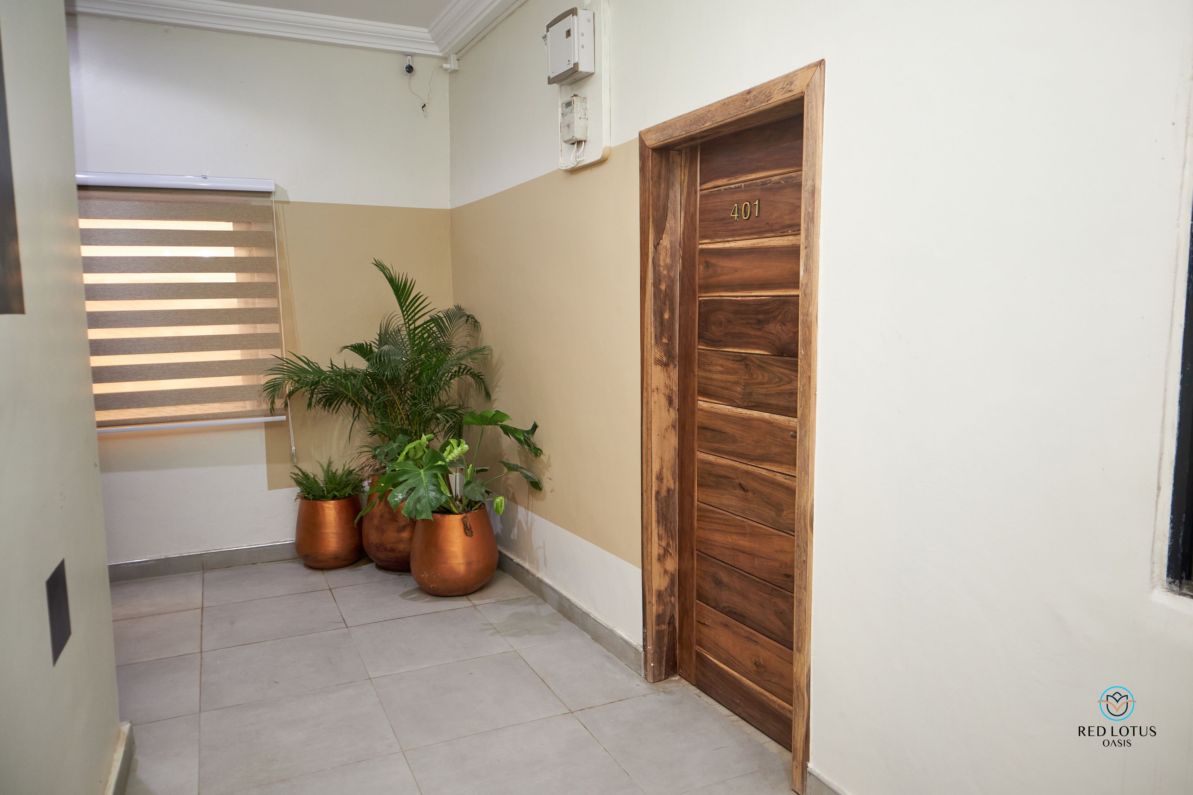 A hallway with a wooden door marked "401", potted plants, and a window with blinds.