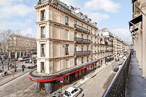 A multi-story building with a red awning and a sign that reads "BERTEIL".