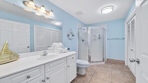 Een badkamer met een witte wastafel, een bad, een toilet en een douchecabine.
