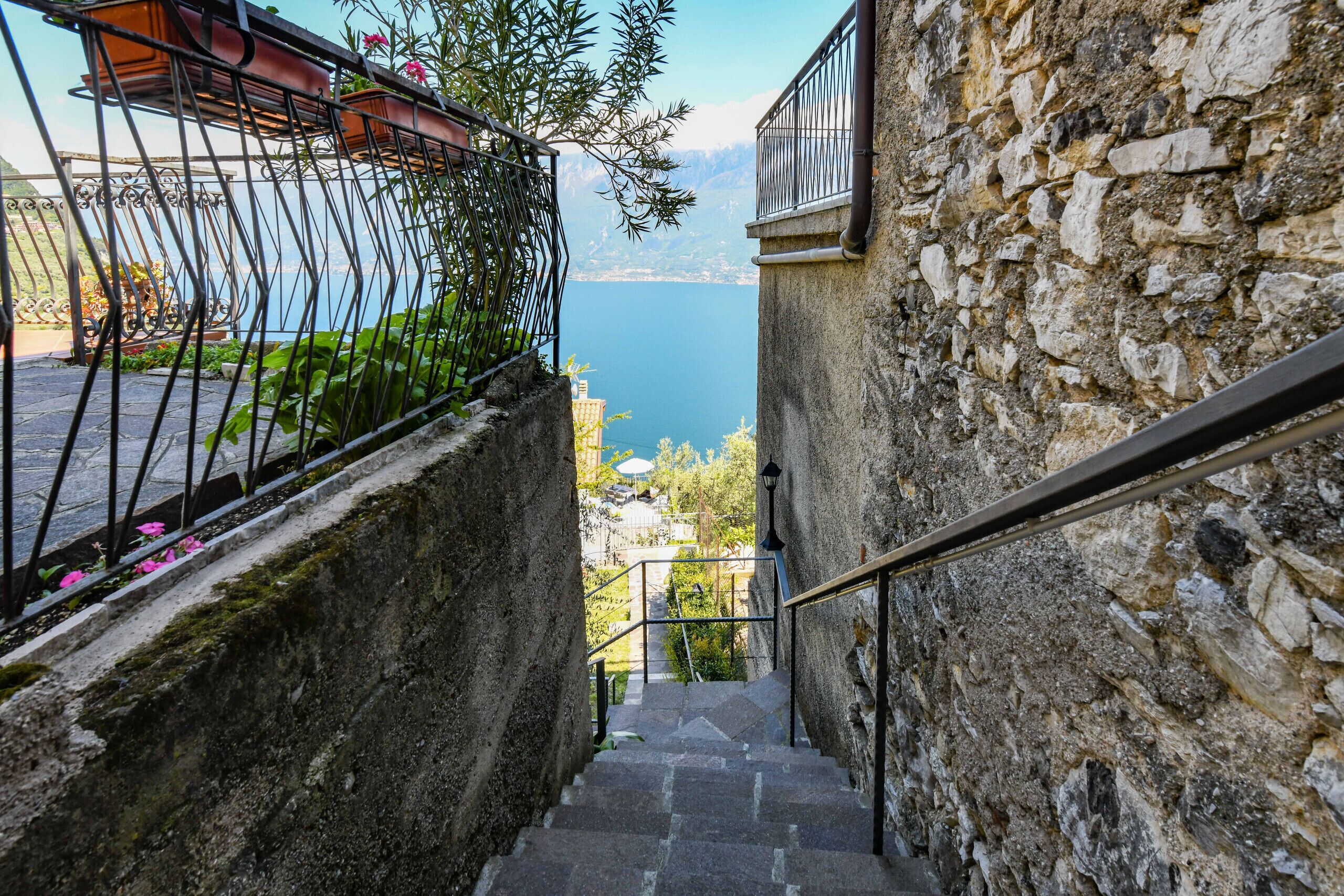 A stone staircase leading to a balcony overlooking a body of water.