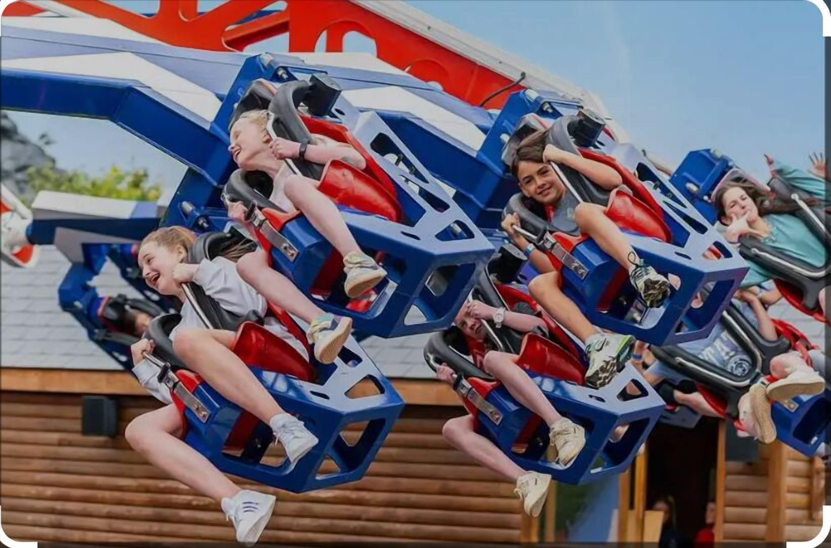 A group of people on a roller coaster with blue and red seats.