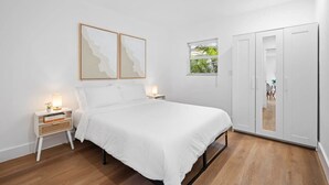 A bedroom with a bed, bedside tables, a wardrobe, and artwork on the wall. - Fresh & Bright Condo 1BR/1BA – Near Riverwalk (Fort Lauderdale)