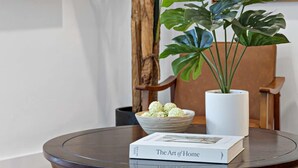 A round wooden table with a book titled "The Art of Home" and a bowl of decorative items. - Fresh & Bright Condo 1BR/1BA – Near Riverwalk (Fort Lauderdale)