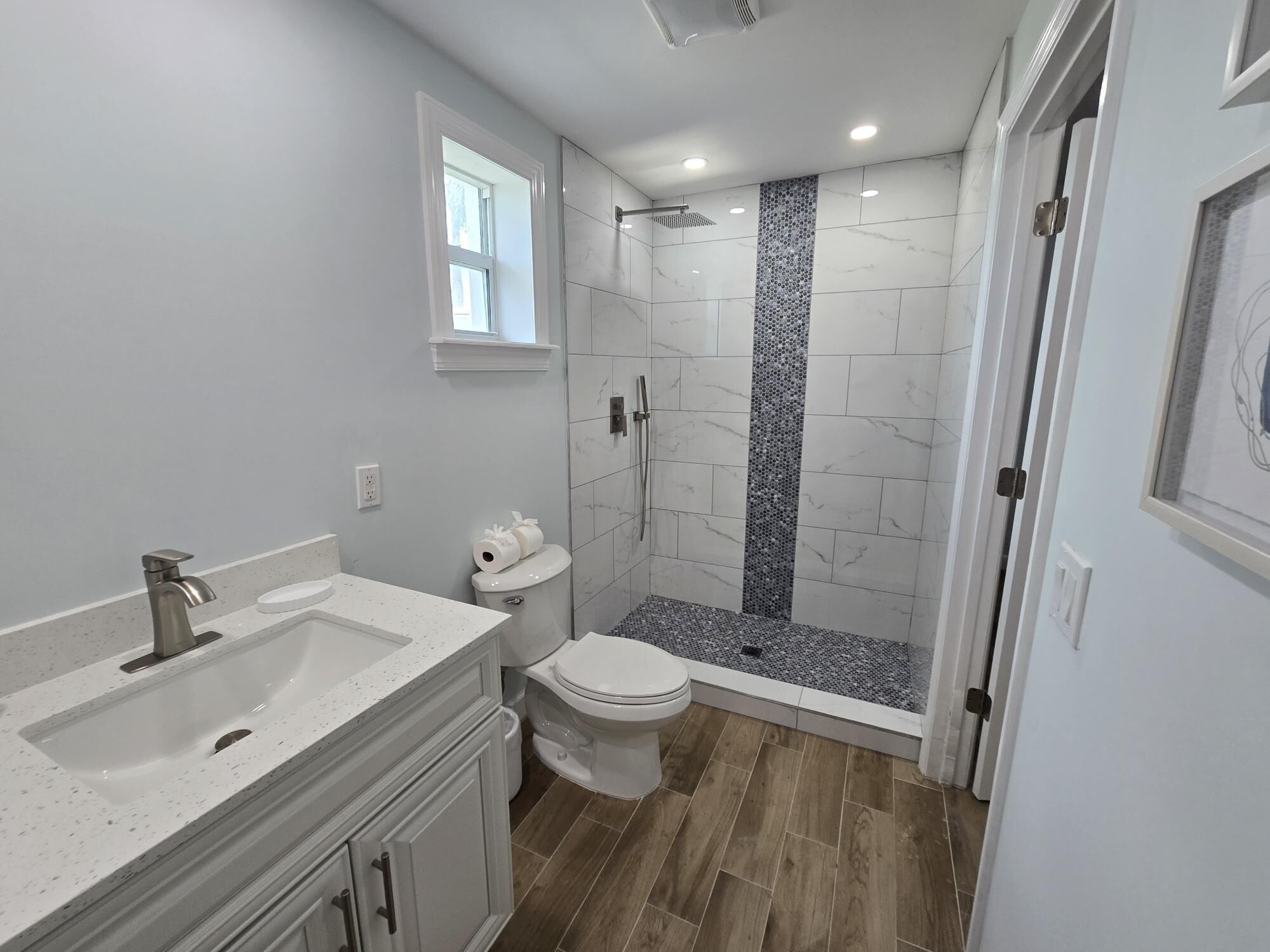 A modern bathroom with a freestanding sink, toilet, and shower.