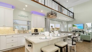A spacious kitchen with a large island, white cabinetry, and a view to the outside.