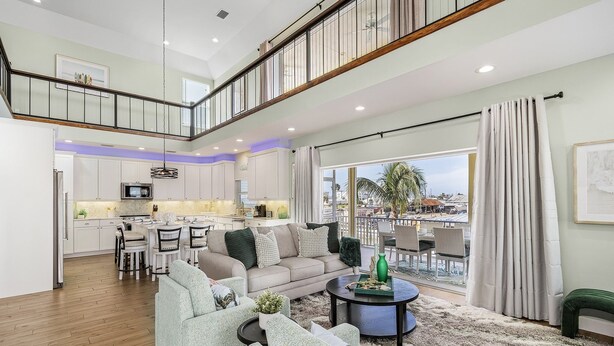 A spacious living area with a high ceiling, a dining area, and a kitchen.
