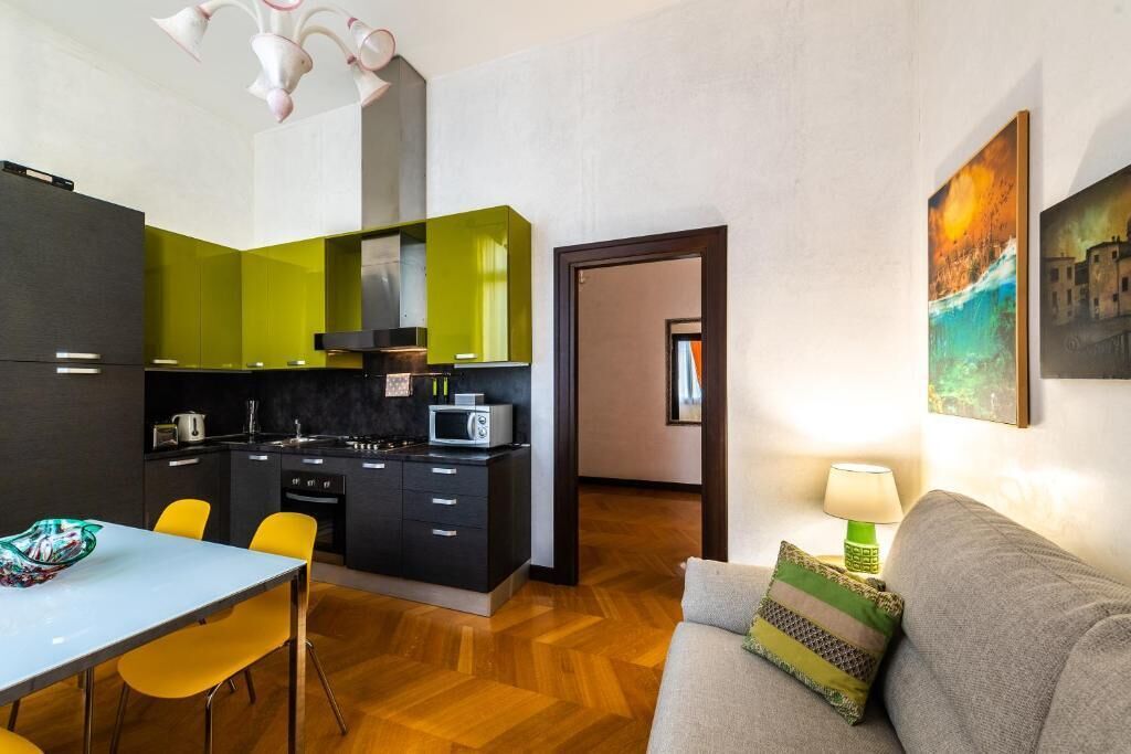 A compact living space with a kitchenette, a dining area, and a sofa.