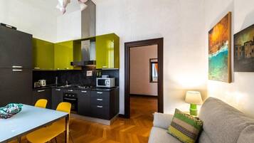 A compact living space with a kitchenette, a dining area, and a sofa.