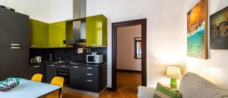 A compact living space with a kitchenette, a dining area, and a sofa.
