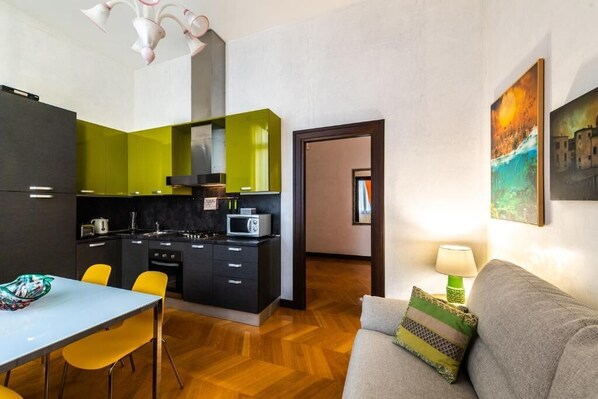A compact living space with a kitchenette, a dining area, and a sofa. - Ca' Sant'Angelo (Venice)