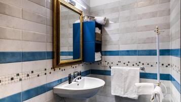 A bathroom with a white sink, a mirror, and a towel rack.